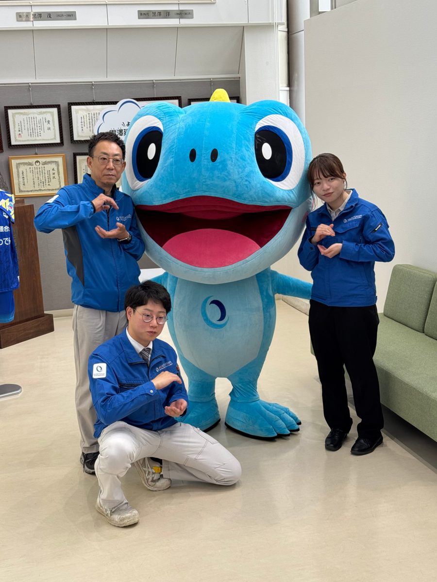 く〜みんと記念撮影する代表取締役と社員